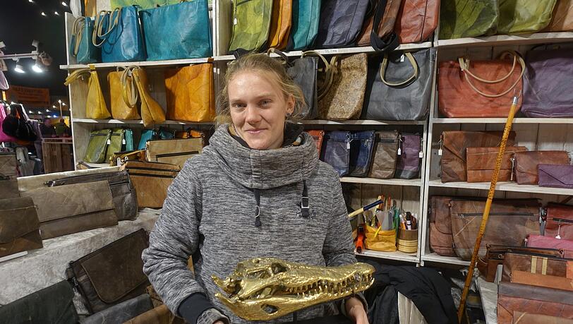 Marlena Frisch mit einem Krokodilkopf vor ihren Taschen aus Teakblättern.