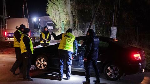 Polizisten versammeln sich vor einem Getreidelager in Przewodow im Südosten Polens. Nach einer Explosion mit zwei Toten hat Polen einen Teil seiner Streitkräfte in erhöhte Bereitschaft versetzt.