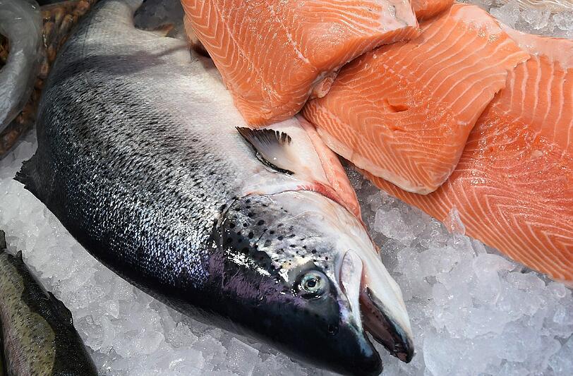 Norwegischer Zuchtlachs wird auf einem Wochenmarkt in Langenhagen auf eine Verkaufstheke angeboten. Foto: Holger Hollemann/Illustration
