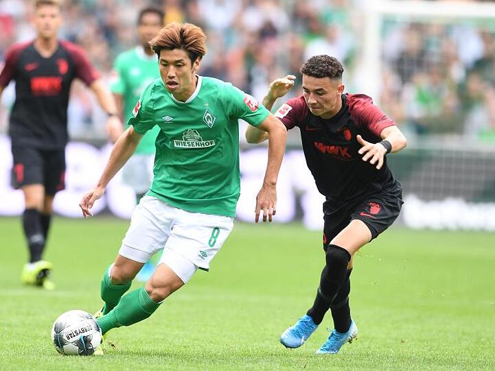 Werders Yuya Osako und Augsburgs Ruben Vargas (l-r.) im Zweikampf um den Ball. Foto: Carmen Jaspersen