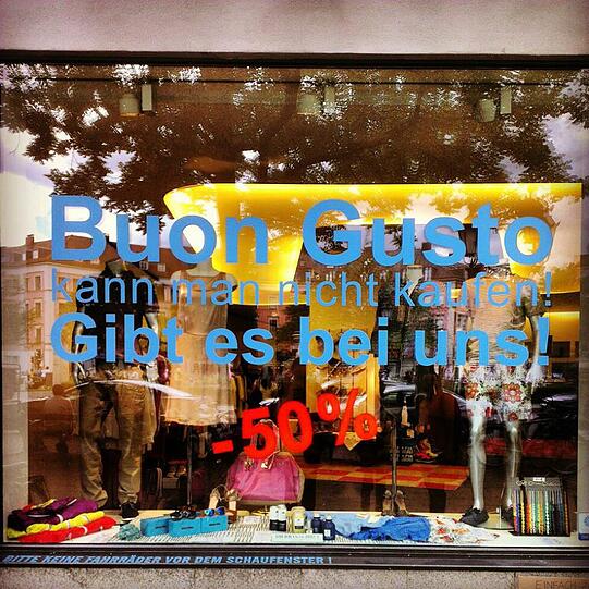 "Buon Gusto kann man nicht kaufen." Aber in diesem Laden schon, oder wie? Und dann auch noch zum halben Preis? Diese Reklame am Gärtnerplatz verwirrt sogar die Hipster