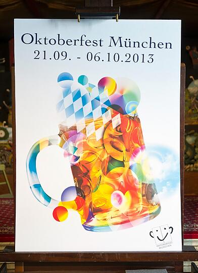 Das am Mittwoch in München vorgestellte Plakat zeigt einen mit bunten Kreisen und verschiedenen Oktoberfest-Motiven gefüllten Maßkrug auf weißem Grund.
