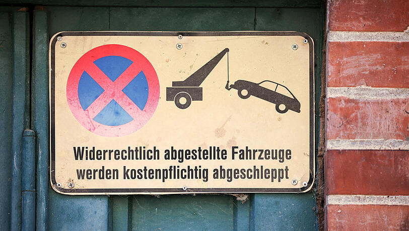 Ein Schild an einem Garagentor weist darauf hin, das widerrechtlich abgestellte Fahrzeuge abgeschleppt werden.  Wer auf Privatgrund park, kann prinzipiell abgeschleppt werden. So auch ein 47-jähriger Münchner, der das nicht einsehen wollte.