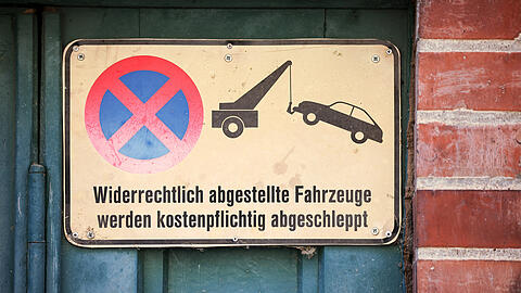 Ein Schild an einem Garagentor weist darauf hin, das widerrechtlich abgestellte Fahrzeuge abgeschleppt werden.  Wer auf Privatgrund park, kann prinzipiell abgeschleppt werden. So auch ein 47-jähriger Münchner, der das nicht einsehen wollte.