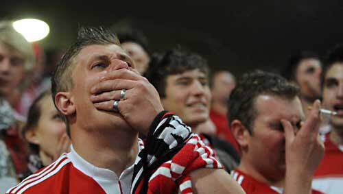 Fassungslos schauen diese Bayern-Fans auf die Videowand in der Allianz Arena Fassungslos schauen diese Bayern-Fans auf die Videowand in der Allianz Arena