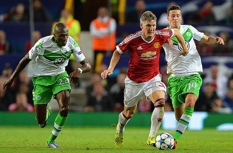 Szene aus dem Hinspiel: Die Wolfsburger Julian Draxler (rechts) und Josuha Guilavogui (links) verfolgen Manchester Uniteds Bastian Schweinsteiger.