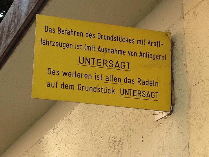In diesen Innenhof in der Maxvorstadt darf man fast gar nichts - zumindest wenn es nach den Schildern geht.