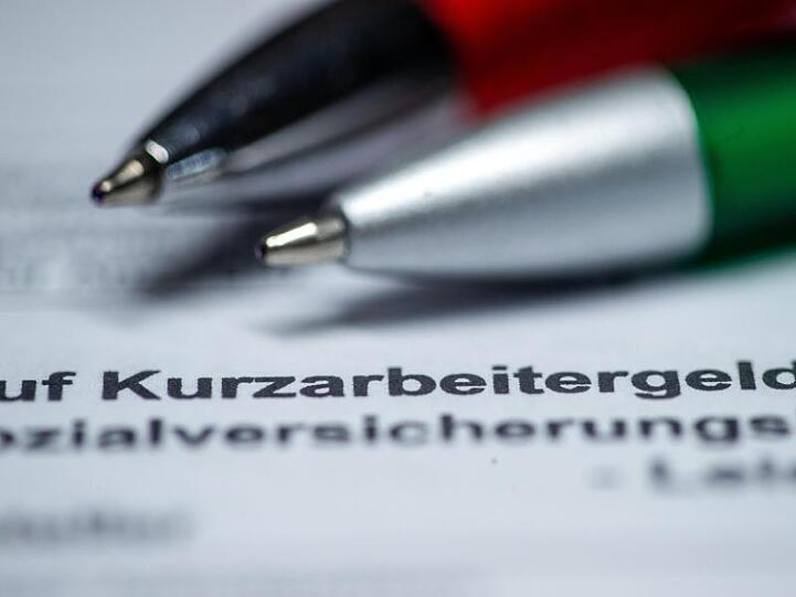 Zwei Kugelschreiber liegen auf einem Antragsformular für Kurzarbeitergeld.