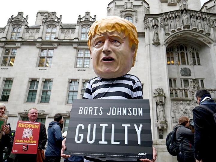 Ein Mann vor dem Gericht hat sich als Boris Johnson in Sträflingskleidung verkleidet. Seine Meinung: Der Premier ist "schuldig".