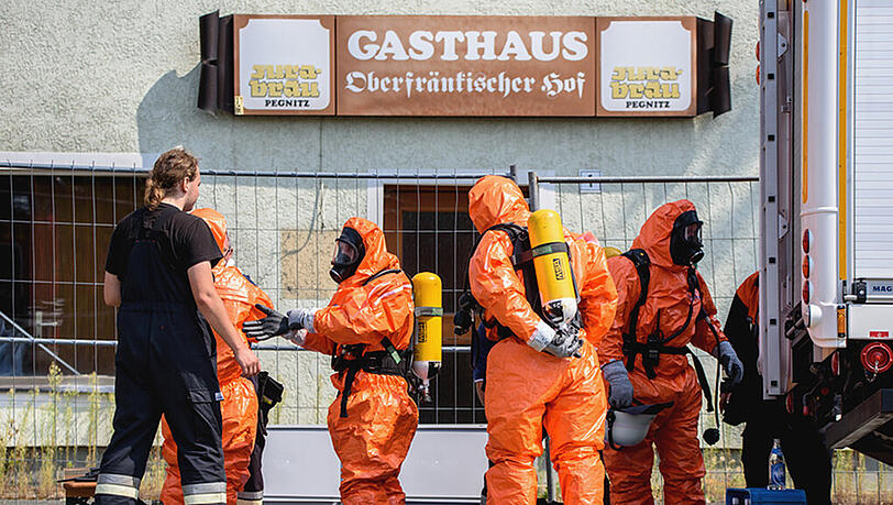 Untersuchung des Absturzortes: Einsatzkräfte der Feuerwehr ziehen sich am 11.08.2015 in Engelmannsreuth Ganzkörper-Schutzanzüge an. Untersuchung des Absturzortes: Einsatzkräfte der Feuerwehr ziehen sich am 11.08.2015 in Engelmannsreuth Ganzkörper-Schutzanzüge an.