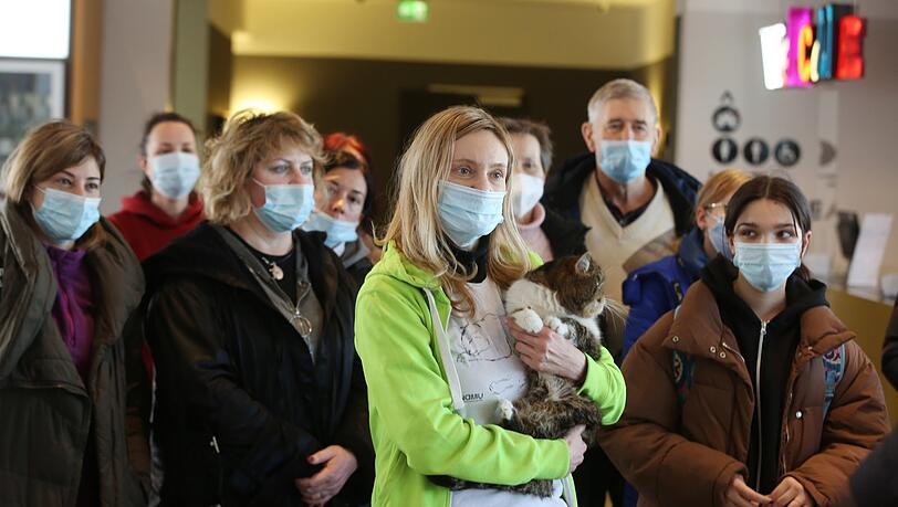 Sogar die Katze hat die Flucht nach München geschafft. Kurz nach der Ankunft im Reisebus sammeln sich die erschöpften Frauen in der Lobby.