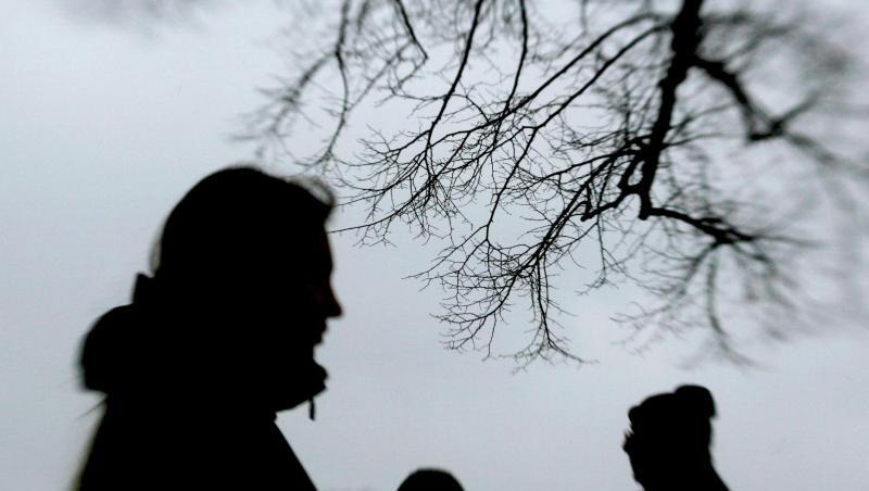 Passanten stehen neben einem Baum. Foto: Julian Stratenschulte/dpa/Archivbild