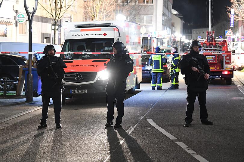 Beamte mit Maschinenpistolen sichern den Bereich um die Tatorte.
