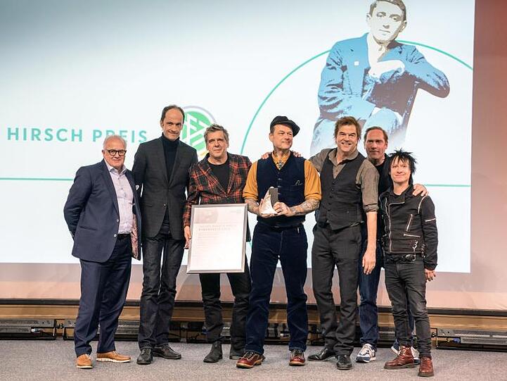 DFB-Präsident Fritz Keller (l), Laudator Thees Uhlmann (2.v.r.) und Die Toten Hosen bei der Verleihung des Julius-Hirsch-Preises.
