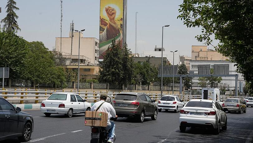 Fahrzeuge fahren in Teheran an einer Plakatwand vorbei, auf der die geballte Faust des verstorbenen iranischen Obersten Führers Ajatollah Ali Chamenei zu sehen ist. (Archivbild) Fahrzeuge fahren in Teheran an einer Plakatwand vorbei, auf der die geballte Faust des verstorbenen iranischen Obersten Führers Ajatollah Ali Chamenei zu sehen ist. (Archivbild)