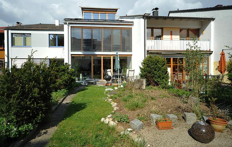 Das Passivhaus (Mitte) hat große Fenster auf der Südseite. Das Haus links wurde neu gedämmt, rechts ist ein herkömmliches. Die Anlage ist Baujahr 1961