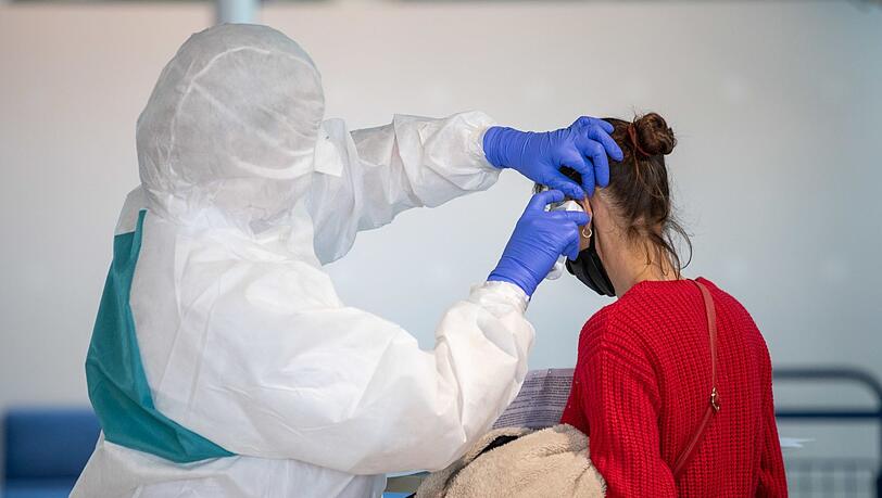 Eine Mitarbeiterin des Bayerischen Roten Kreuzes (BRK) misst bei einer Frau Körpertemperatur. Eine Mitarbeiterin des Bayerischen Roten Kreuzes (BRK) misst bei einer Frau Körpertemperatur.