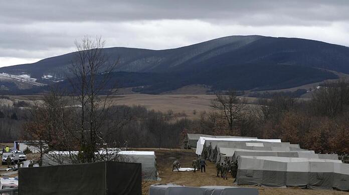 Bosnische Soldaten stehen vor provisorischen Zelten im Camp Lipa außerhalb von Bihac. Nach der gescheiterten Verlegung von Hunderten Flüchtlingen in feste Unterkünfte im Landesinneren hat die bosnische Armee damit begonnen, im Elendslager Lipa im Nordwesten des Landes Zelte zu errichten.