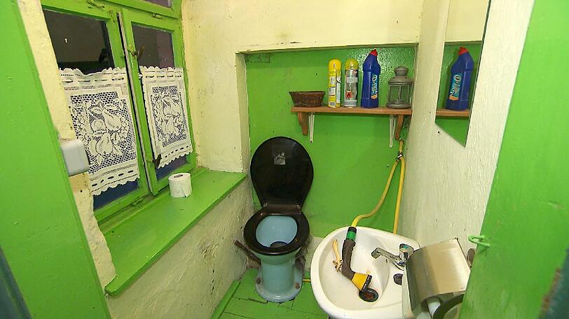 Die Toilette hat einen Gartenschlauch statt Wasserspülung. 'Halbautomatisch. Das geht dann runter in die Jauchegrube und wird dann mit aufs Feld gefahren', erklärt Gerhard.