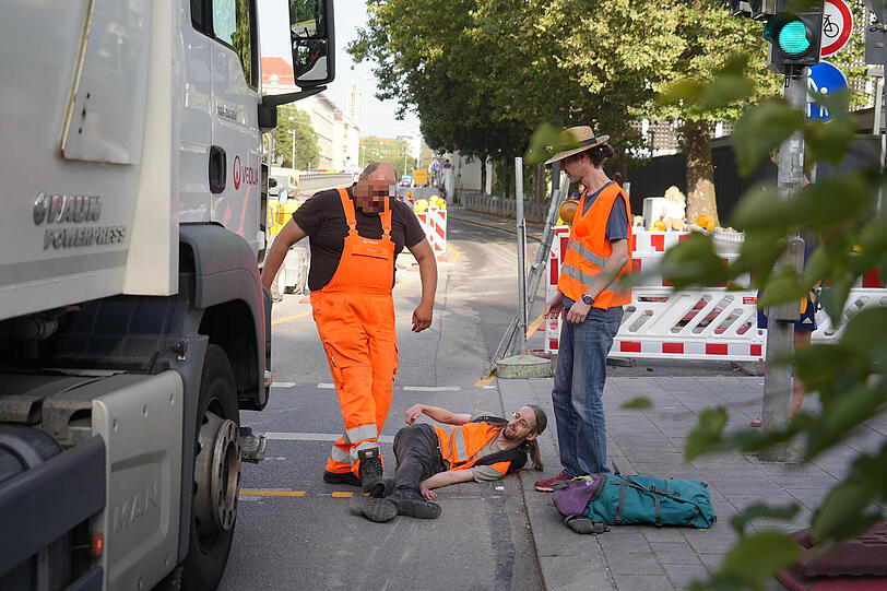 Ein Lkw-Fahrer tritt einen am Boden liegenden Aktivisten.