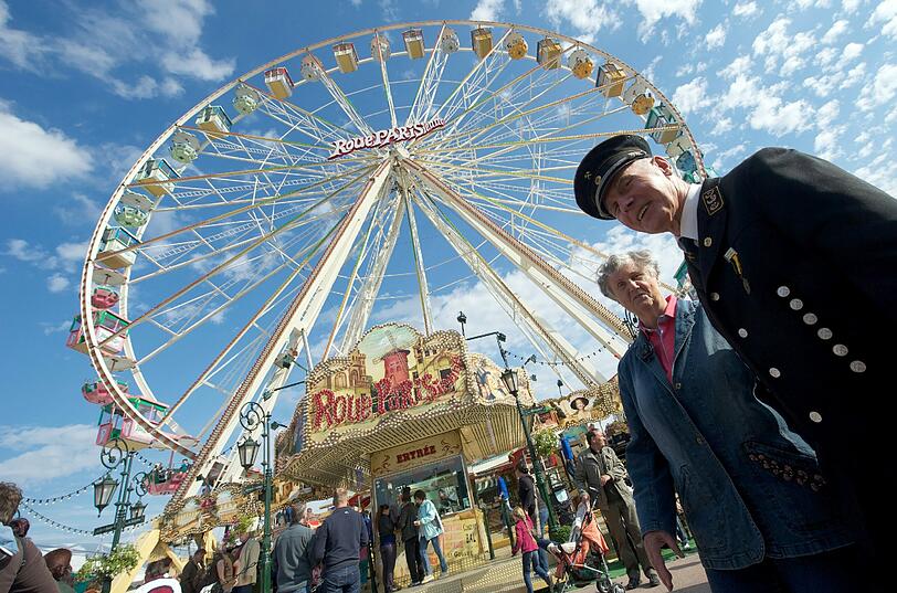 Ein Bergmann geht mit seiner Frau am 14.09.2012 an dem Riesenrad auf der «Eisleber Wiese» in Eisleben in Sachsen-Anhalt vorbei.