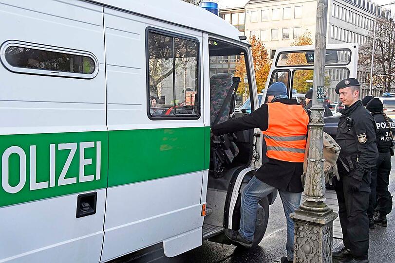 Neun Mitglieder der Bewegung "Letzte Generation" blockieren die Widenmayerstraße in München, indem sie sich auf die Straße kleben.