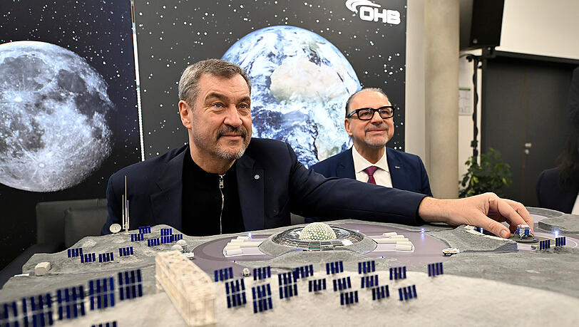 Ministerpr&auml;sident Markus S&ouml;der (CSU) und Esa-Direktor Josef Aschbacher sitzen vor einem Modell des "European Moonport". S&ouml;der hofft, dass dort eines Tages auch eine bayerische Flagge steht.