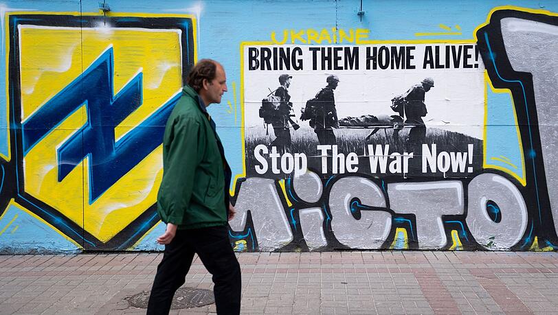 Ein Mann geht in Kiew an einem Poster vorbei, das zur Unterstützung der Verteidiger von Mariupol angebracht wurde. Ein Mann geht in Kiew an einem Poster vorbei, das zur Unterstützung der Verteidiger von Mariupol angebracht wurde.