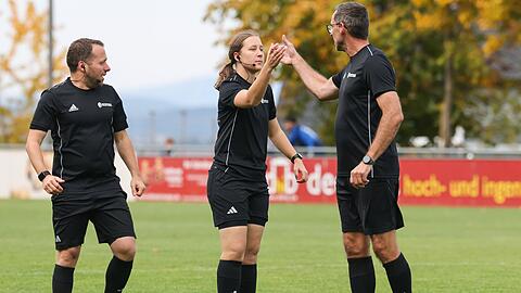 Das Schiedsrichter-Trio klatscht sich vor dem Spiel ab.