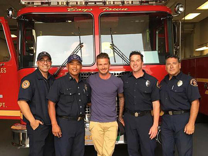 Fußball-Star David Beckham fühlt sich sichtlich wohl unter Feuerwehrmännern