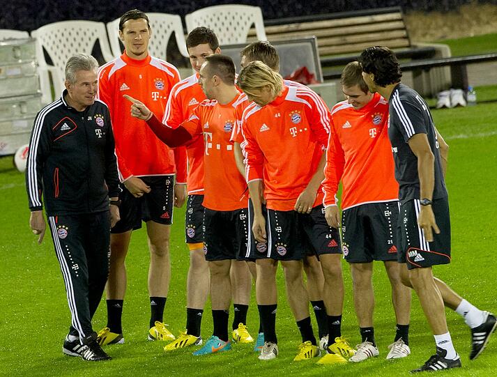 Trainer Jupp Heyncke gibt einer Gruppe Spieler Anweisungen.