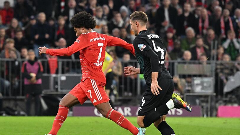Serge Gnabry (l) von München kämpft mit Niklas Stark von Bremen um den Ball.