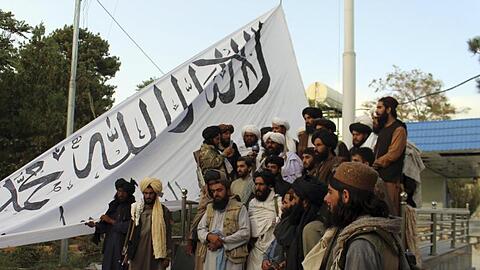 Taliban-Kämpfer posieren in der Provinz Gasni mit ihrer Fahne vor dem Haus des Gouverneurs.