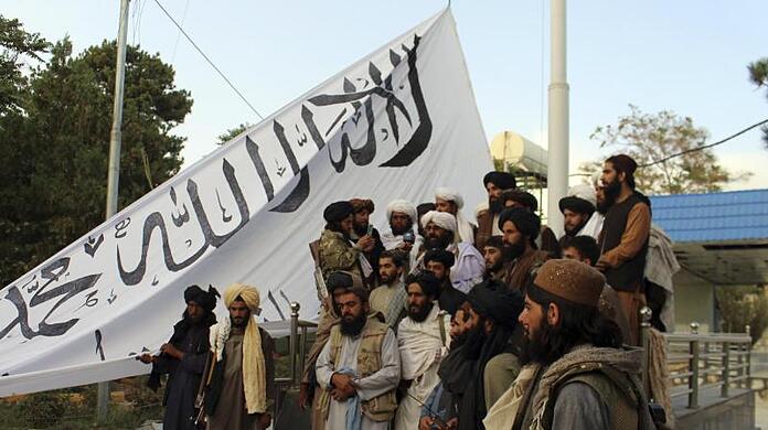 Taliban-K&auml;mpfer posieren in der Provinz Gasni mit ihrer Fahne vor dem Haus des Gouverneurs.