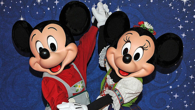 Die Disney-Figuren Mickey Mouse (l) und Minnie Mouse tanzen am 08.11.2017 beim Pre-Opening im neuen Disney Store in München (Bayern).