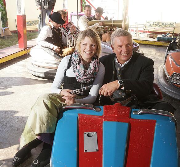 Wiesn-Chef Dieter Reiter und Musikerin Birgit von der Kapelle Kaiserschmarrn beim Autoscooter.
