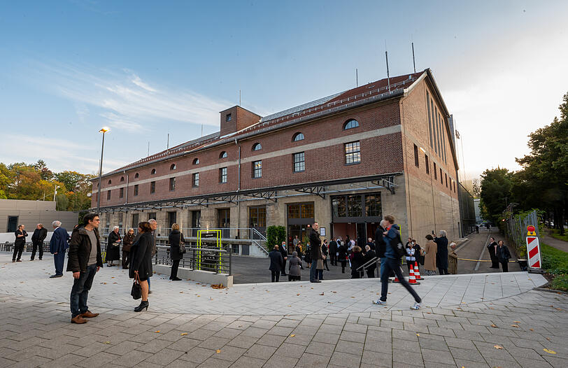 Menschen stehen zu Beginn der Eröffnung der Isarphilharmonie vor dem Gebäude.