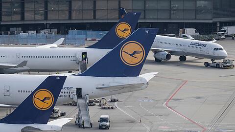 Passagierjets der Lufthansa stehen auf einem Flughafen.