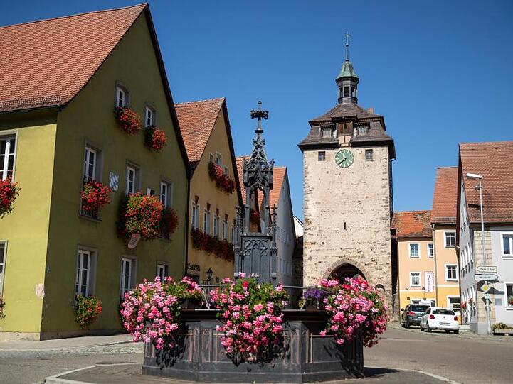 Leutershausen: Der historische Röhrenbrunnen steht vor dem Rathaus (M) und dem Oberen Tor Turm. Foto: Daniel Karmann