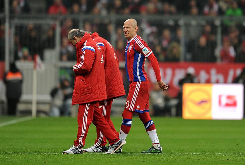 Mit schmerzverzerrtem Gesicht trottet Arjen Robben den Betreuern hinterher.
