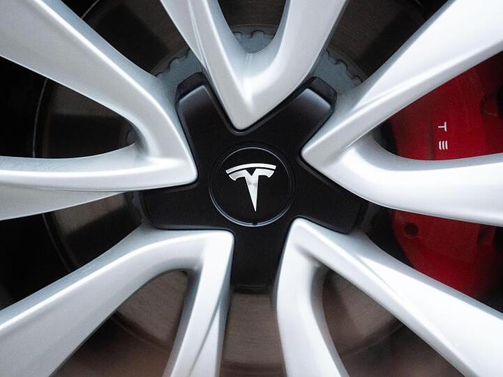 Ein Tesla-Logo auf einer Tesla-Felge. Foto: Julian Stratenschulte/dpa/Archivbild
