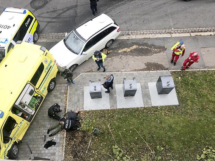 Polizisten halten den bewaffneten Mann am Boden fest.
