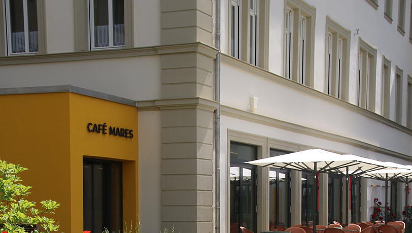 Garten mit dem Eingang des täglich geöffneten Cafés. In dem Hof waren früher Parkplätze. Garten mit dem Eingang des täglich geöffneten Cafés. In dem Hof waren früher Parkplätze.
