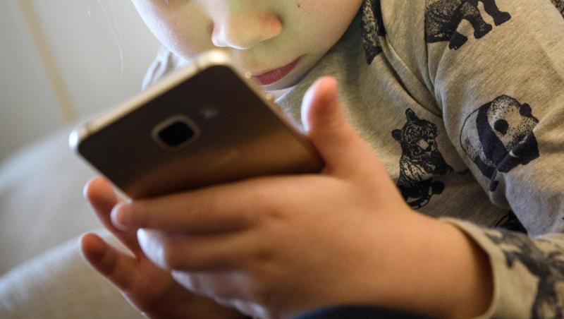 Ein kleines Mädchen spielt auf einem Smartphone. Ein kleines Mädchen spielt auf einem Smartphone.
