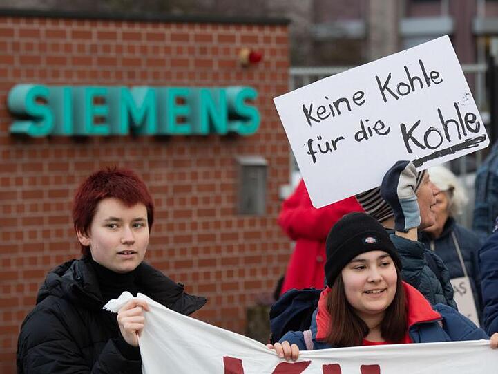 Aktivisten demonstrieren gegen die Lieferung von Siemens-Technik für ein Kohlebergwerk in Australien. Foto: Julian Stratenschulte/dpa