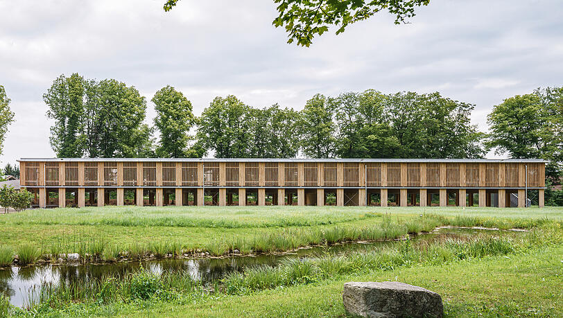 Das langgestreckte, offene Holzparkdeck soll sich mit seiner nat&uuml;rlichen Holzlamellen-Fassade in die umgebende Naturlandschaft einf&uuml;gen.