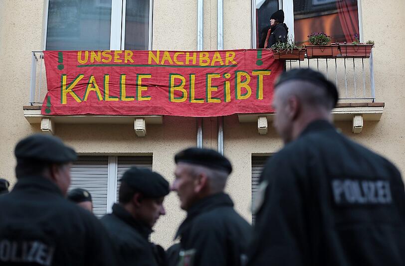 Polizisten stehen in Köln während einer Zwangsräumung vor einem Wohnhaus mit einem Plakat "Unser Nachbar Kalle bleibt". Anwohner und Unterstützer protestierten vor der Räumung gegen Mieterhöhungen und Luxussanierungen.