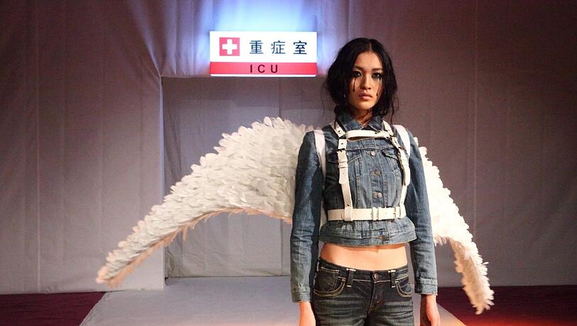 Eine besondere Aktion: Ein Model in Peking mit Beinbinde soll die giften Kleidung der großen Modemarken symbolisieren Eine besondere Aktion: Ein Model in Peking mit Beinbinde soll die giften Kleidung der großen Modemarken symbolisieren