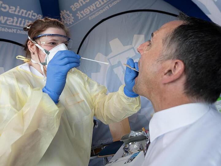 Ein Mitarbeiterin des Robert Koch-Instituts entnimmt einen Rachenabstrich.