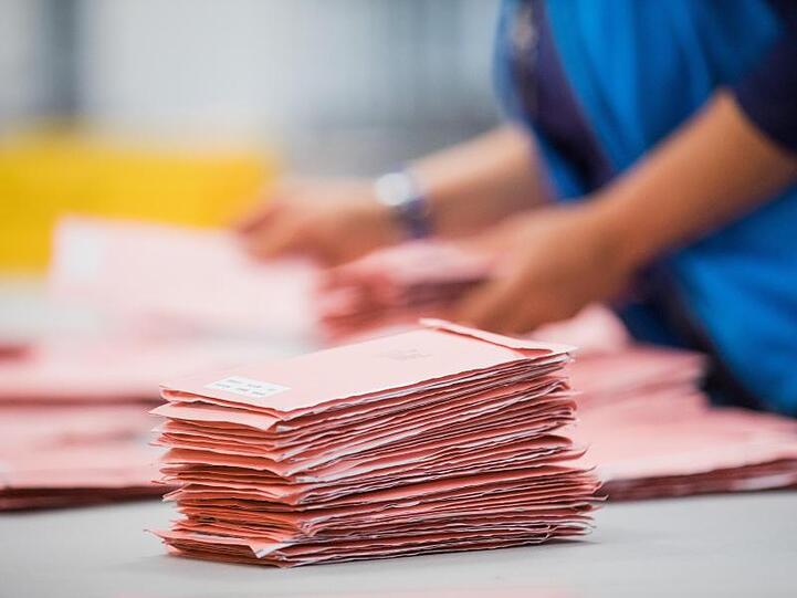 Wahlhelfer sortieren Wahlbriefe. Foto: picture alliance/Rolf Vennenbernd/dpa/Symbolbild